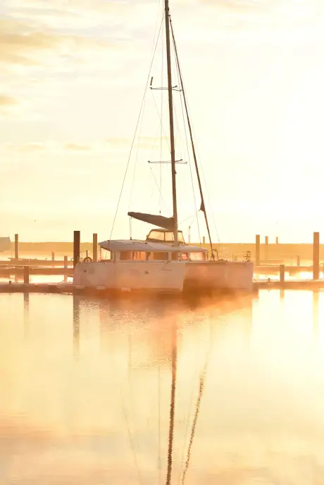 Katamaran im Hafen bei Sonnenuntergang, reparaturbedürftige Yachten und Yachtelektronikservice.